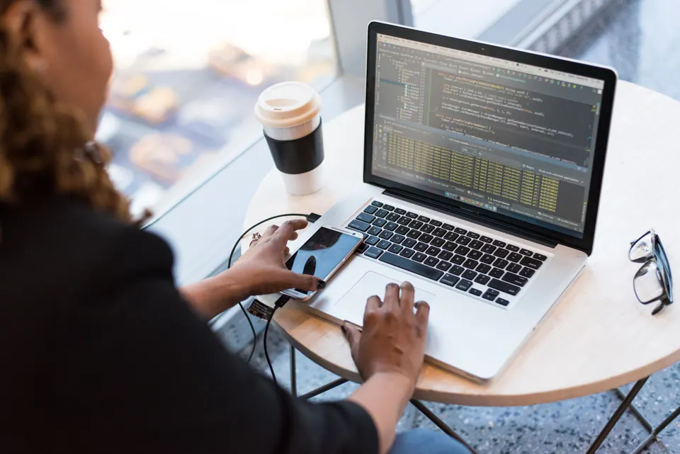 Développeuse travaillant sur du code sur son ordinateur portable