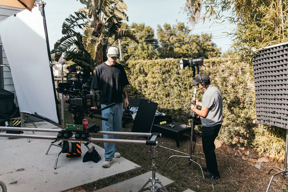 Équipe de tournage installant caméra et éclairage en extérieur